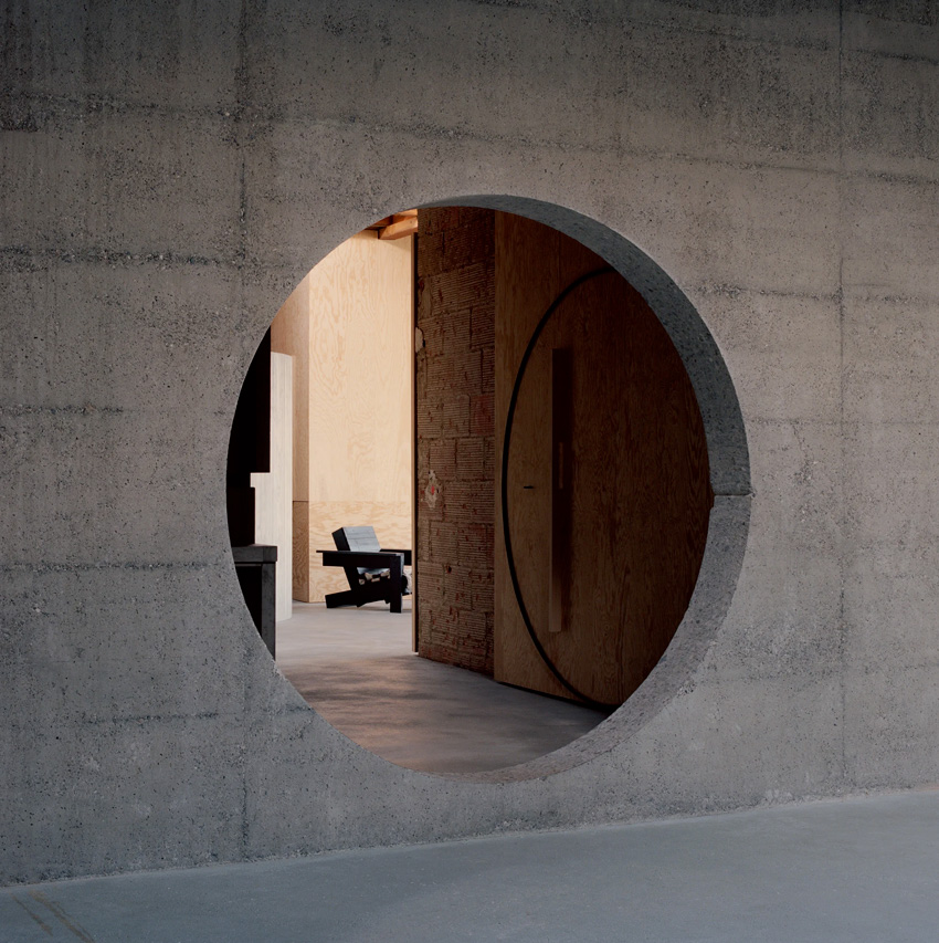 Maison d'architecte en béton, brutaliste, inspiration Paulo Mendes da Rocha. Ouverture circulaire entre les pièces.